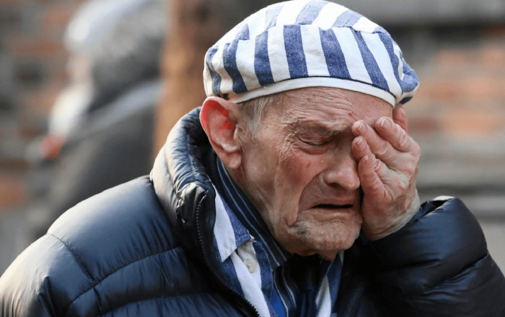 Sobrevivente do holocausto chora em Auschwitz.