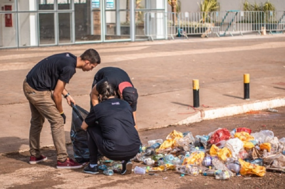 Voluntários coletam lixo deixado por foliões. Imagem: G1.